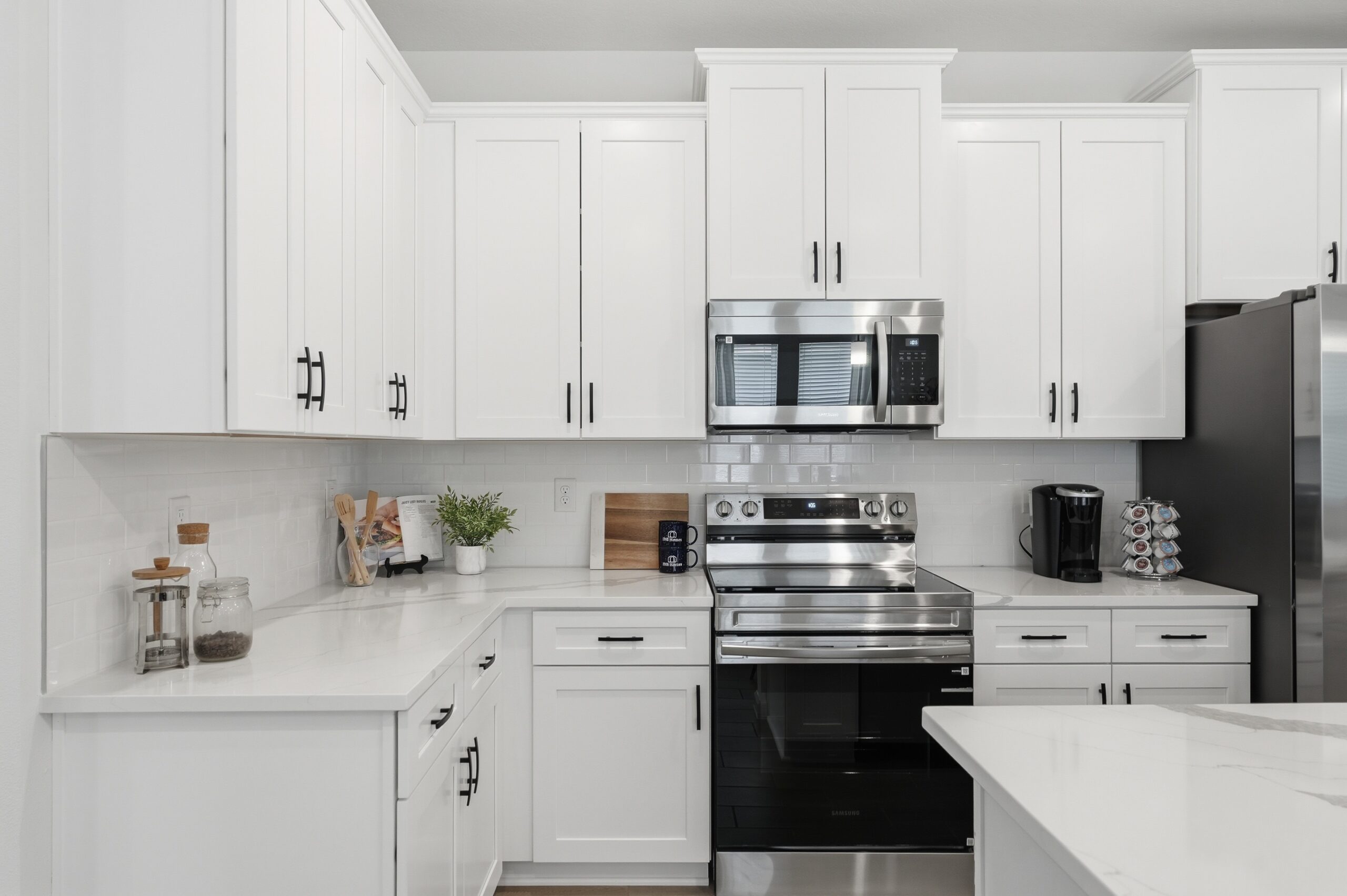 Modern kitchen with island and stainless steel appliances in a new Tumbleson home in St. Cloud, FL